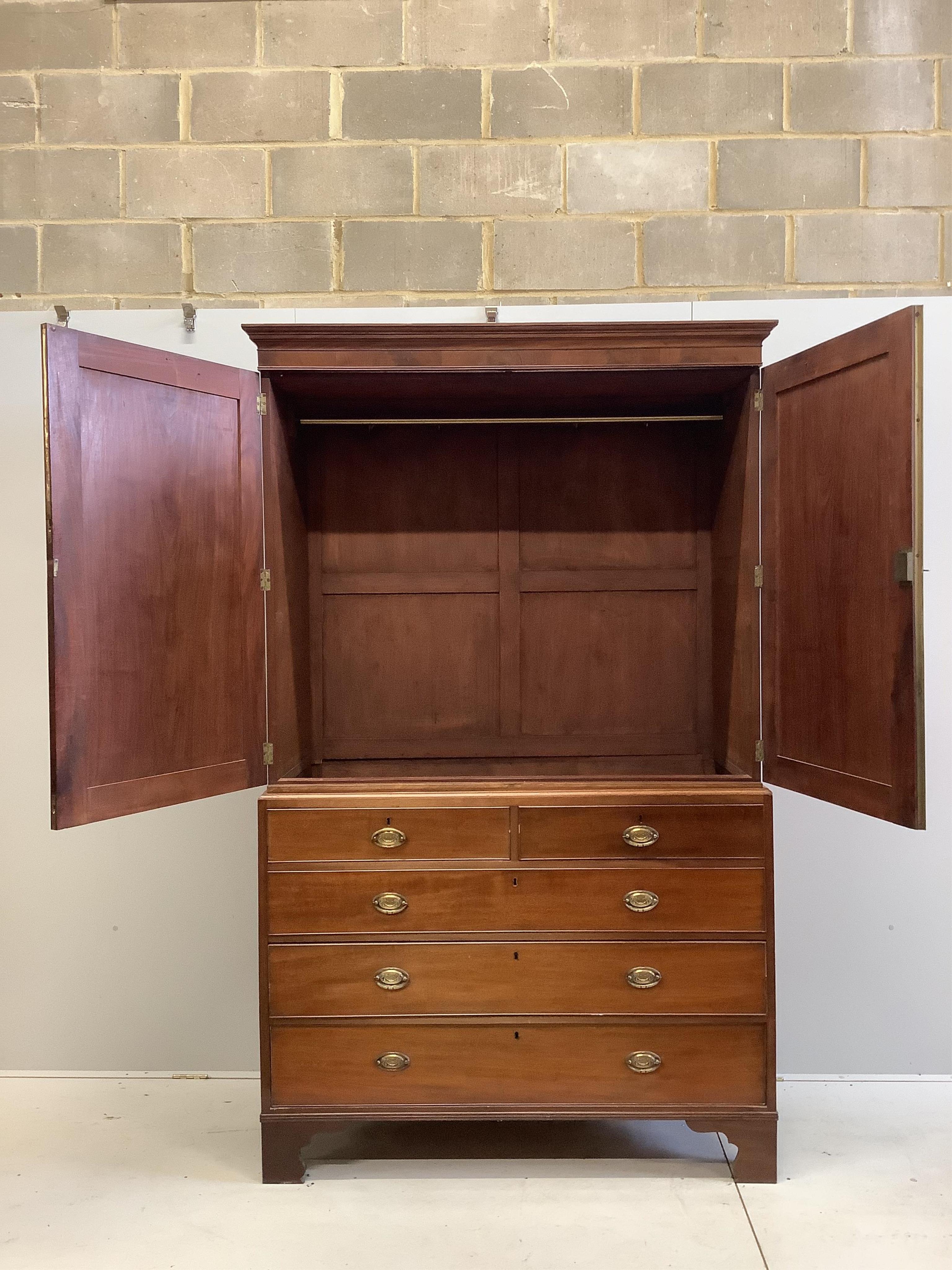 A George III mahogany linen press, converted to hanging cupboard, width 130cm, depth 58cm, height 215cm. Condition - fair, sliding trays deficient